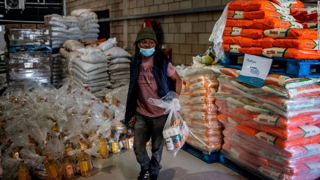 Un voluntario carga paquetes de alimentos marcados para ser distribuidos en los Servicios Comunitarios de 'Meals on Wheels' de Sudáfrica en julio. Se prevé que la tasa de pobreza empeore este año, especialmente en los países de "ingresos medios" como Sudáfrica.