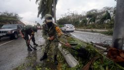 Members of the Mexican Army remove fallen trees after the passage of Hurricane Delta in Cancun, Quintana Roo state, Mexico, on October 7, 2020. - Hurricane Delta slammed into Mexico's Caribbean coast early Wednesday, toppling trees, ripping down power lines and lashing a string of major beach resorts with winds of up to 110 miles (175 kilometers) per hour. (Photo by PEDRO PARDO / AFP)