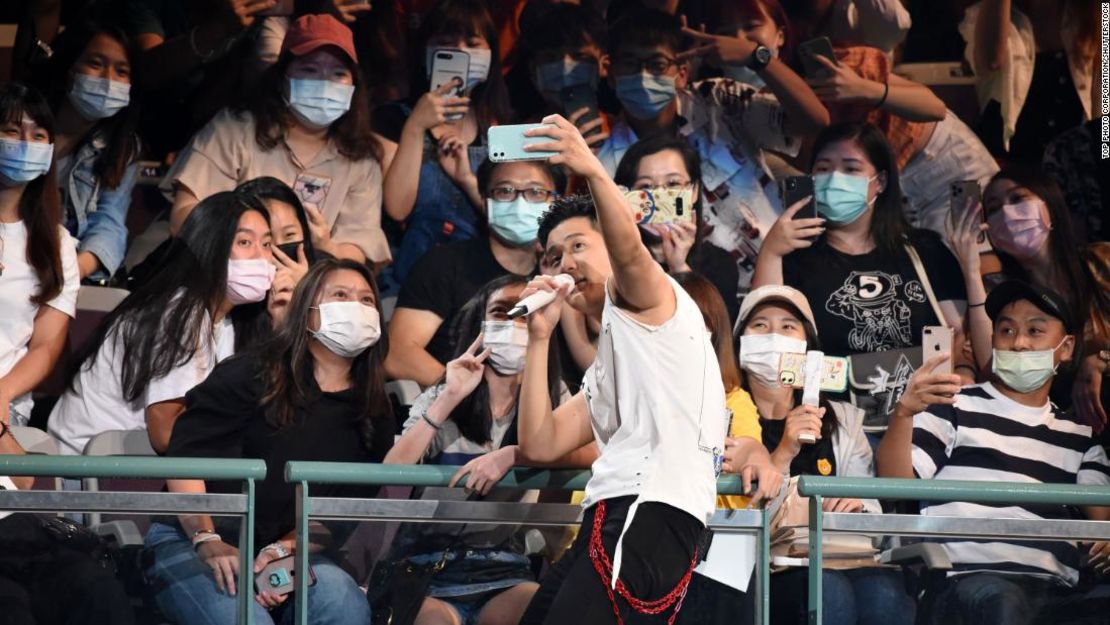 El cantante Eric Chou se toma una selfie con miembros enmascarados de la audiencia mientras se presenta en un concierto en Taipei, Taiwán, el 9 de agosto de 2020.