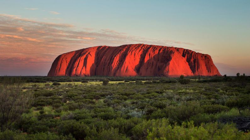 3. Parque Nacional Uluru-Kata Tjuta, Australia: el monolito de arenisca de Uluru tiene un aspecto espectacular bajo una puesta de sol radiante y dorada, que destaca toda su belleza natural.