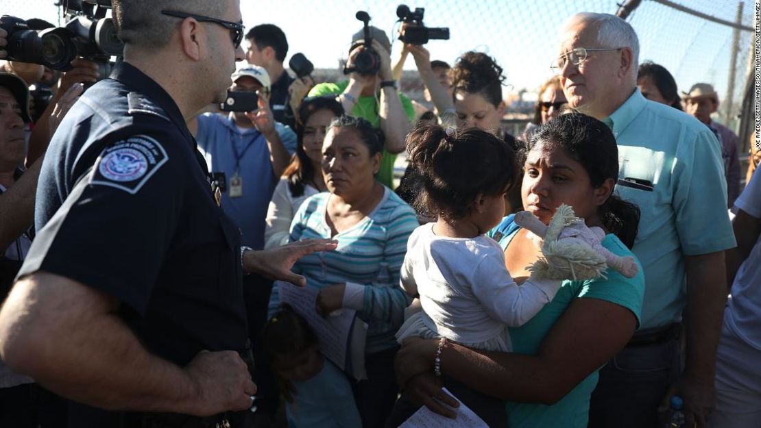 Familias migrantes que buscan asilo frente a agentes de la Patrulla Fronteriza en la frontera entre EE.UU. y México en junio de 2018.