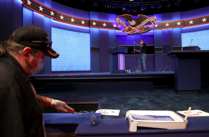 Trabajadores preparan el escenario para el debate, el miércoles 21 de octubre. Hubo un acuerdo de última hora para eliminar las barreras de plexiglás que se habrían colocado entre los candidatos.