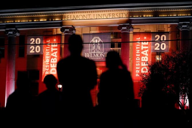 Algunas personas ven las manifestaciones que tienen lugar en la Universidad de Belmont antes del debate.