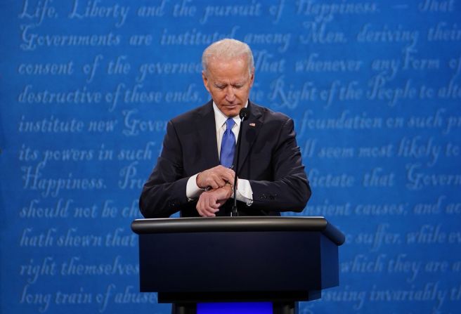 Biden mira su reloj durante el debate, que duró un poco más de 90 minutos.