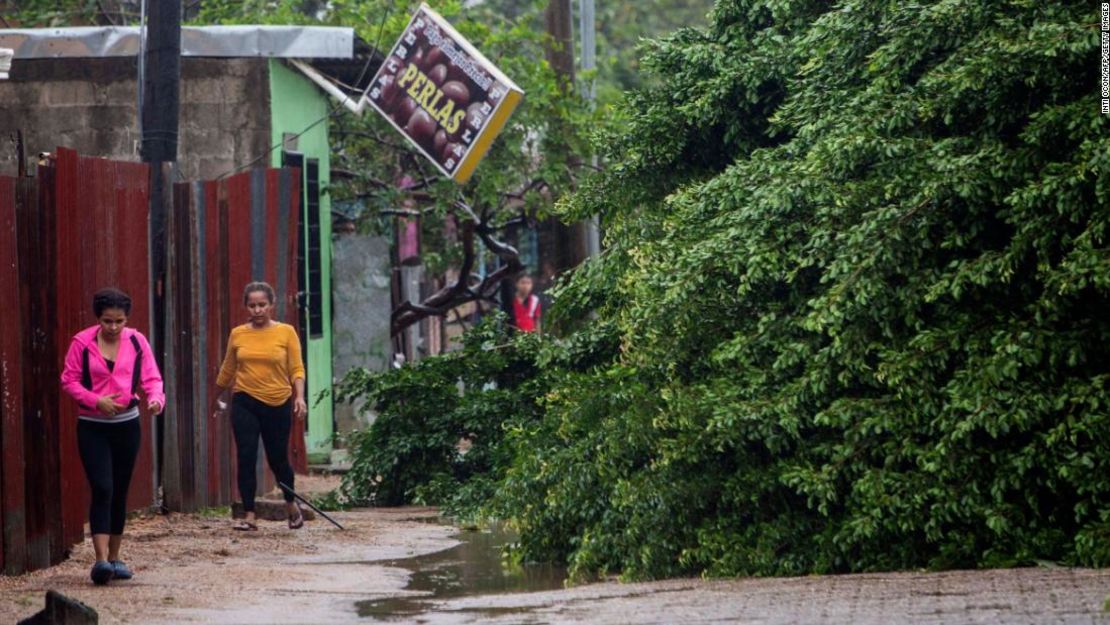 Mujeres caminan junto a los árboles caídos el martes por la mañana en Puerto Cabezas, Nicaragua.