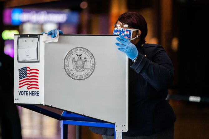 Una funcionaria electoral desinfecta una cabina en el Museo de Brooklyn en Nueva York el 3 de noviembre.