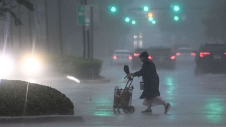 Una mujer cruza la calle durante una fuerte lluvia y viento mientras la tormenta tropical Eta se acerca al sur de Florida, en Miami, Florida el 8 de noviembre de 2020.