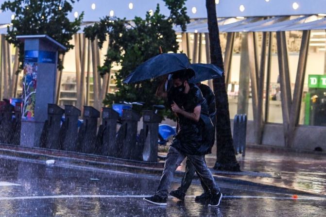 Personas cruzan la calle durante una jornada de fuertes lluvias y vientos mientras la tormenta tropical Eta se acerca al sur de Florida, en Miami, Florida, el 8 de noviembre de 2020.