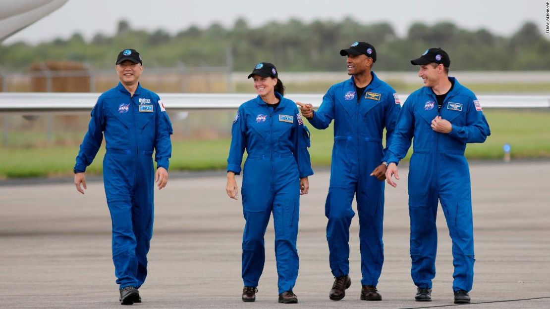 De izquierda a derecha, los astronautas Soichi Noguchi, Shannon Walker, Victor Glover y Michael Hopkins caminan hacia la conferencia en el Centro Espacial Kennedy el domingo.