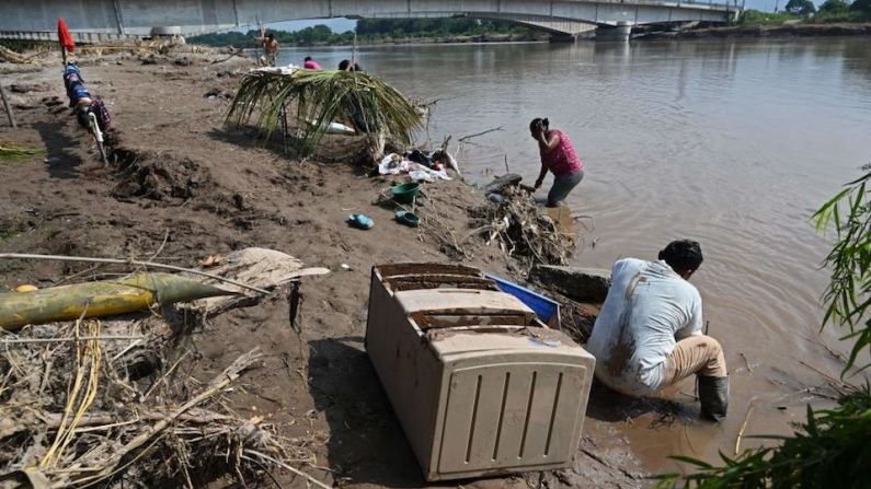 Personas afectadas por el paso del huracán Eta lavan ropa en el río Ulúa en El Progreso, departamento de Yoro, Honduras, el 15 de noviembre de 2020, antes de la llegada del huracán Iota.