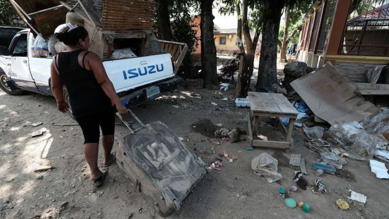 Una mujer lleva una maleta con pertenencias rescatadas de las inundaciones mientras los pobladores locales evacuan sus hogares antes de la llegada del huracán Iota el 15 de noviembre de 2020 en La Lima, Honduras.