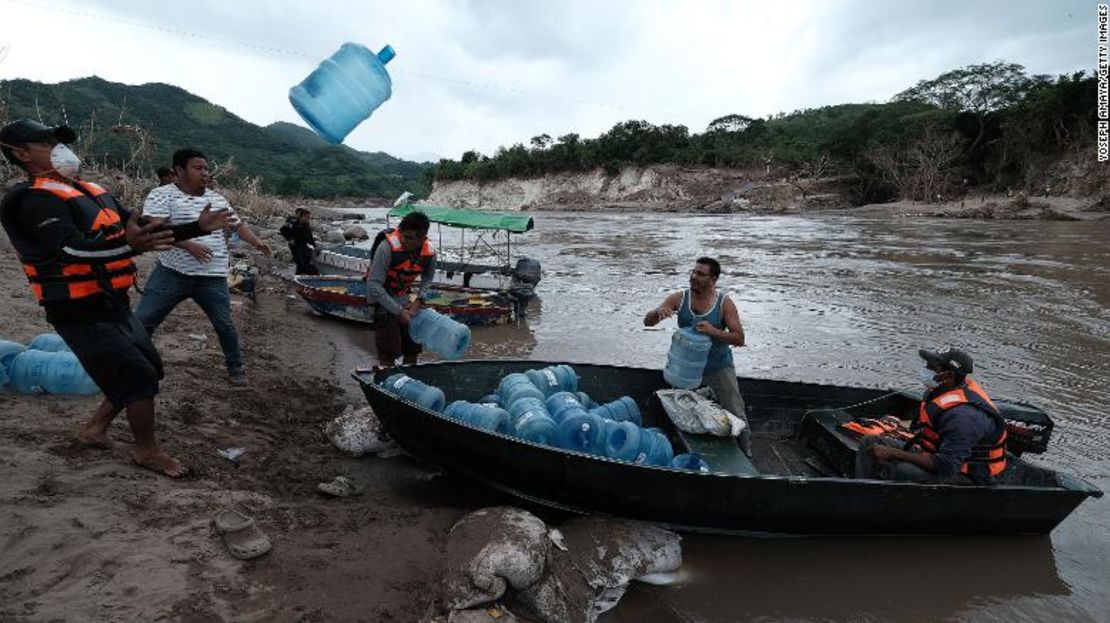 Gente de la colonia San Rafael en Honduras se prepara para la escasez de agua al cruzar el río Ulúa para evacuar el lunes.