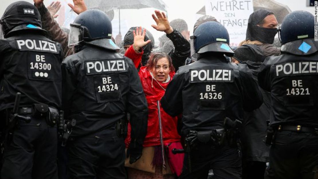 Manifestantes levantan las manos frente a agentes de policía durante una protesta contra las restricciones gubernamentales por coronavirus en Berlín, el 18 de noviembre de 2020.