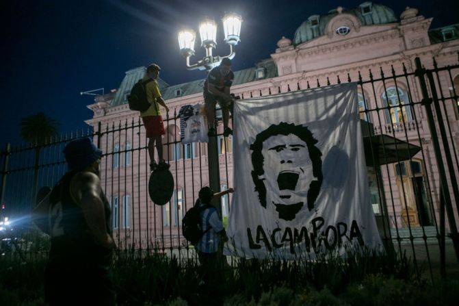 Seguidores cuelgan una pancarta con la imagen de la exestrella del fútbol Diego Maradona en la Casa Rosada, sede del Gobierno argentino, en Buenos Aires.