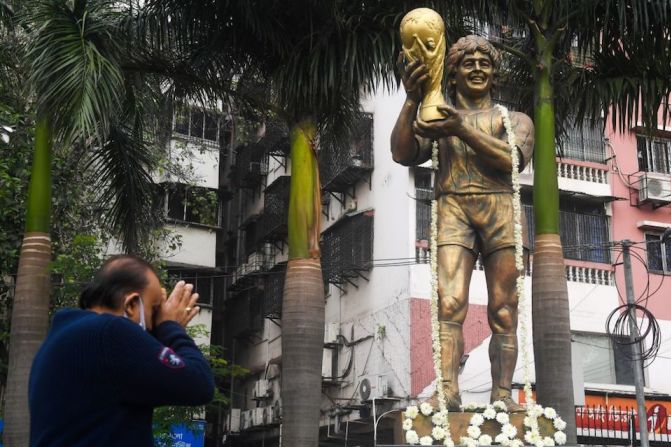 Un hombre rinde homenaje frente a una estatua del jugador argentino Diego Maradona en Calcuta, India.