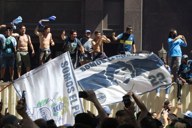 Aficionados se paran sobre un contenedor mientras comienzan los disturbios durante el velatorio de Diego Maradona el 26 de noviembre de 2020 en el centro de Buenos Aires, Argentina.