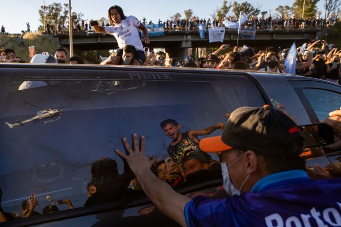 Un aficionado toca el coche fúnebre que lleva el cuerpo de Diego Maradona por la carretera 25 de Mayo hasta el cementerio Jardín de Paz de Bella Vista el 26 de noviembre de 2020 en Buenos Aires, Argentina.