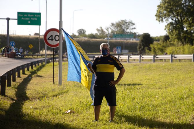 Un seguidor con una camiseta de Boca Juniors espera al lado de la autopista que pase el coche fúnebre que lleva el cuerpo de Diego Maradona hacia el cementerio Jardín de Paz de Bella Vista, el 26 de noviembre de 2020 en Buenos Aires.