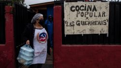 Chilean Ruth Lagos helps to deliver lunches that she and several collaborators cooked at her home in Santiago, on July 17, 2020. - Lagos leads the "Las Guerreras" soup kitchen, which prepares lunch for families with few resources who have been affected by the pandemic. Various initiatives multiplied during the months of the pandemic to alleviate hunger in Chile: soup kitchens are reproduced in the poorest neighborhoods and also several restaurants, some gourmet, turned on their kitchens so that no one goes to bed without eating. (Photo by MARTIN BERNETTI / AFP)