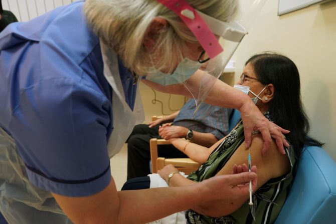 La enfermera jubilada Suzanne Medows administra la vacuna de Pfizer a Ranju Shukla en el Royal Victoria Infirmary en Newcastle, en el norte de Inglaterra.