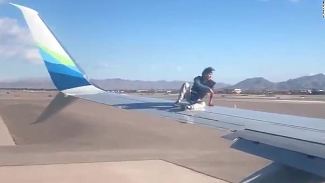 Una imagen de un video grabado por un pasajero muestra al hombre sentado en el ala del avión de Alaska Airlines.