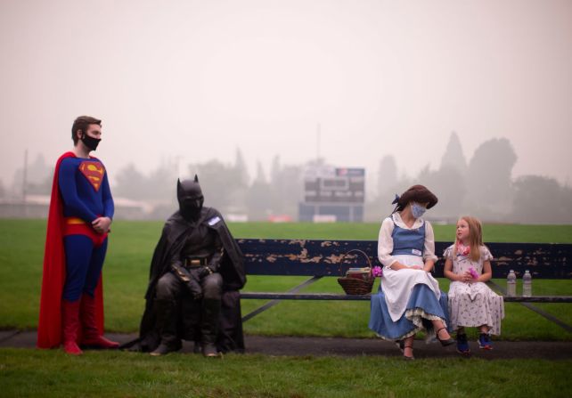 10 de septiembre: Lexi Longstreet, vestida como Bella de "La Bella y la Bestia", habla con un niño cerca de Springfield High School en Springfield, Oregon. Muchas familias se quedaron allí después de que un incendio forestal los obligara a evacuar sus hogares. Longstreet, propietaria de Enchanted Parties en la cercana Junction City, se ofreció como voluntaria para visitar el sitio junto con Dylan y Tanner Alexander, quienes estaban vestidos como Superman y Batman. “Mucha gente realmente necesita alguien con quien hablar en este momento”, dijo Dylan Alexander a The Oregonian. Beth Nakamura / The Oregonian / AP