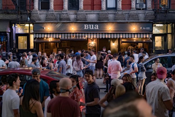 12 de junio –– Personas beben afuera de un bar en el East Village de Nueva York. Los bares de la ciudad aún no tenían permitido abrir, pero mucha gente salió a las calles después de que Nueva York entrara en la fase 1 de su plan de reapertura el 8 de junio.