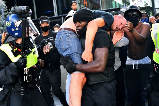 13 de junio –– Patrick Hutchinson lleva a un hombre herido a un lugar seguro durante una protesta de Black Lives Matter en Londres. Al parecer, el hombre fue agredido en medio de violentos enfrentamientos. Hutchinson le dijo a CNN que ayudó al hombre porque no quería que la razón principal de las protestas se perdiera en un momento de violencia.