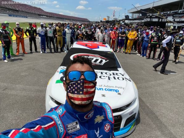 22 de junio –– El piloto de NASCAR Bubba Wallace tuiteó esta selfie antes de una carrera de Cup Series en Talladega, Alabama. Compañeros automovilistas y miembros del equipo caminaron junto al coche de Wallace para demostrarle su apoyo. Wallace, el único piloto negro en el circuito superior de NASCAR, ha sido un defensor abierto del movimiento Black Lives Matter. Una soga fue hallada en en el garaje de su equipo en Talladega, pero el FBI investigó y concluyó que la soga era una cuerda de tiro de la puerta del garaje que se había ubicado allí en octubre de 2019, mucho antes de que fuera asignada al equipo de Wallace.