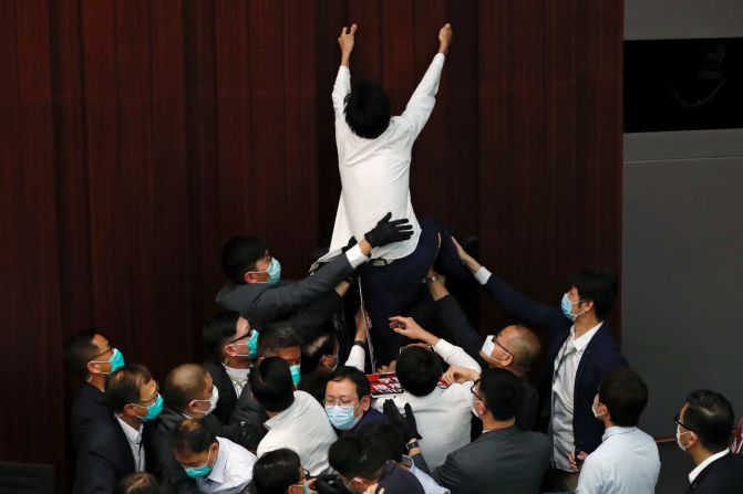 8 de mayo - El legislador prodemocracia Eddie Chu Hoi-dick se pelea con miembros de la seguridad y legisladores proChina durante una reunión del Comité de la Cámara de Representantes en Hong Kong. Chu y varios otros legisladores fueron sacados de la sala por la seguridad después de no cumplir con las advertencias del presidente Starry Lee de sentarse, informó Bloomberg.