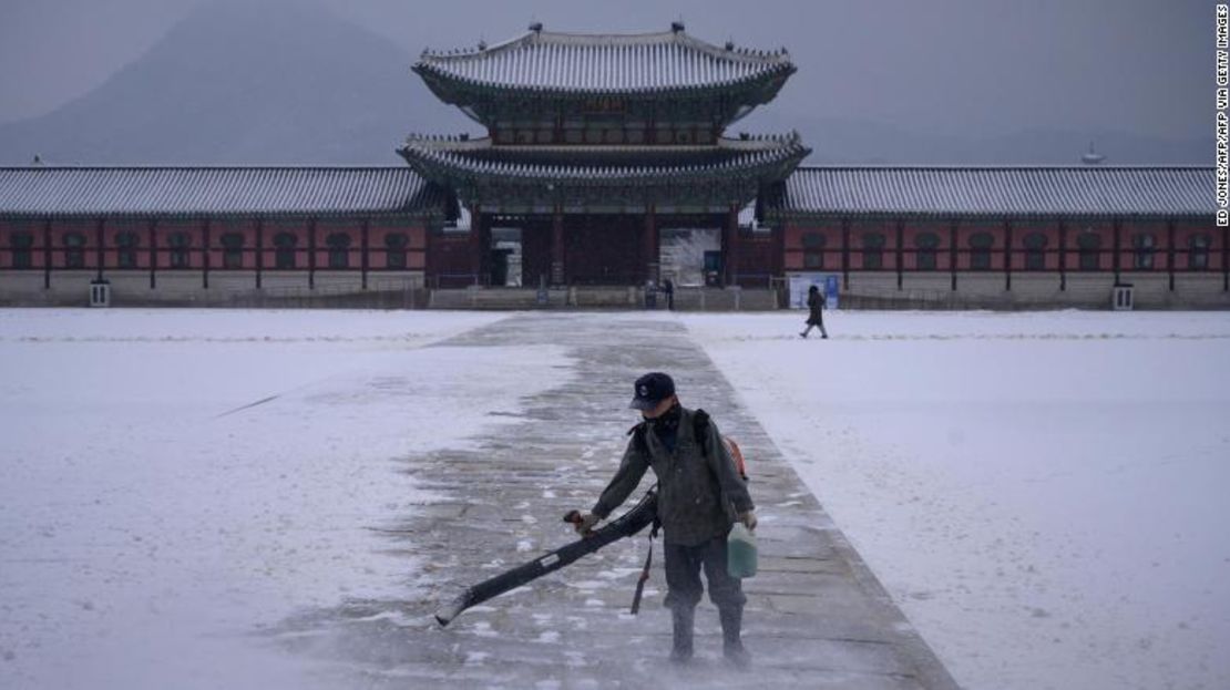 Un trabajador usa un soplador para quitar la nieve de un patio en el palacio Gyeongbokgung en el centro de Seúl el 13 de diciembre de 2020.