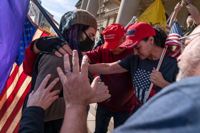 7 de noviembre – Partidarios del presidente de Estados Unidos, Donald Trump, rezan con un manifestante contrario en Lansing, Michigan, después de que Joe Biden fuera proyectado como el ganador de las elecciones. David Goldman / AP