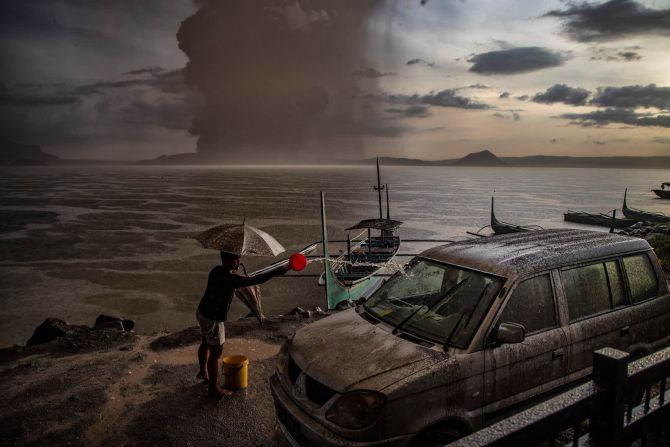 12 de enero - Un residente de Talisay, Filipinas, salpica agua sobre un vehículo cubierto de cenizas después de la erupción del volcán Taal. La erupción arrojó cenizas al aire hasta a 14 kilómetros de distancia y forzó evacuaciones a gran escala. Ezra Acayan / Getty Images