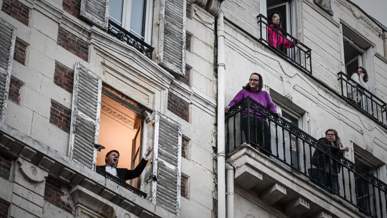 26 de marzo — El cantante de ópera Stephane Senechal canta para sus vecinos desde la ventana de su apartamento en París. Fue el décimo día de un bloqueo estricto en Francia.