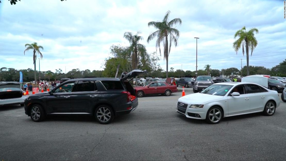 Los conductores abren los maleteros de sus coches para conseguir alimentos gratis en el centro comercial de Boynton Beach.