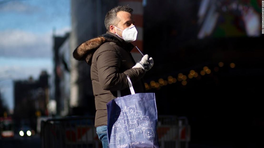 Usar una mascarilla en público ayuda a proteger a la comunidad de la propagación del coronavirus. Un hombre lleva un cubrebocas en Times Square en Nueva York el 10 de diciembre.