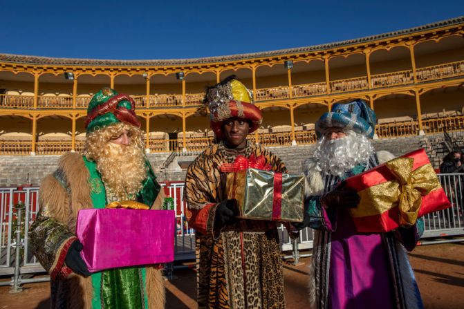 Los Tres Reyes Magos sostienen cajas de obsequios antes de recibir a los niños en la plaza de toros de Aranjuez, España.