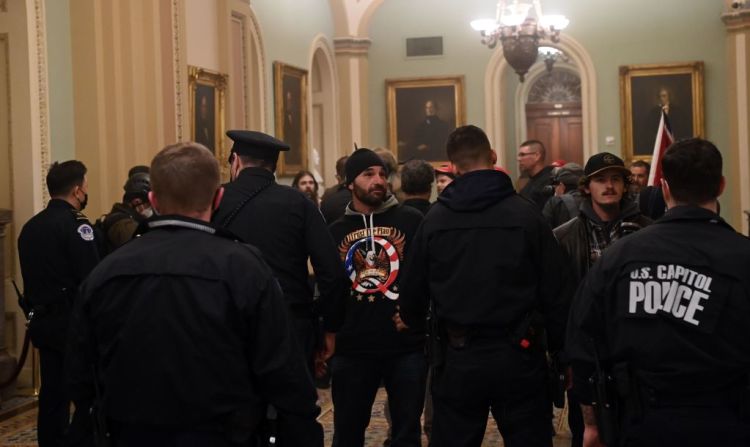 Se vieron a policías inclinándose por encima de las cercas de metal para golpear a las personas que intentaban cruzarlas.