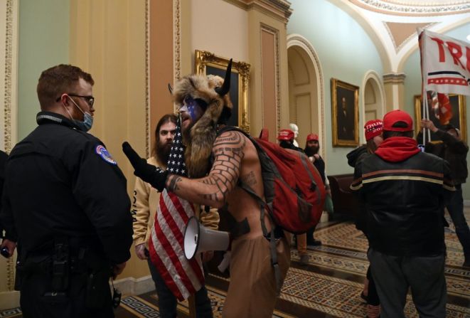 Un agente de la policía del Capitolio frente a una horda de manifestantes pro-Trump cuando entraron al Capitolio el 6 de enero de 2021. Los manifestantes irrumpieron las barreras de seguridad y entraron al Congreso que debatía la certificación de los votos electorales.