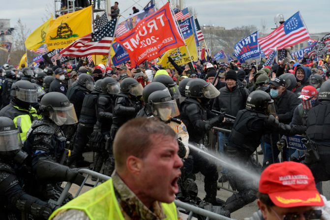La policía lanza agua contra manifestantes que se enfrentaron para tratar de ingresar al Capitolio en Washington.