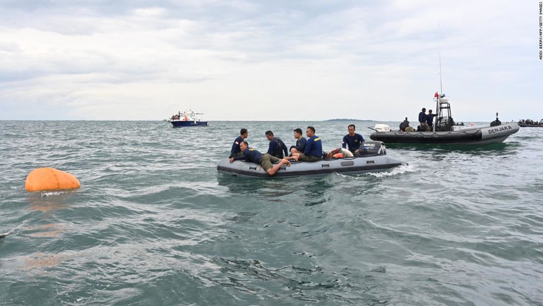 Los buzos de la Marina utilizan un dispositivo de flotación para recuperar los restos del avión.