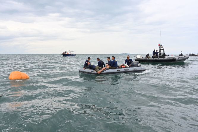 Buzos de la Armada de Indonesia usan un dispositivo de flotación para recuperar los restos durante las operaciones de recuperación cerca de la isla Lancang.