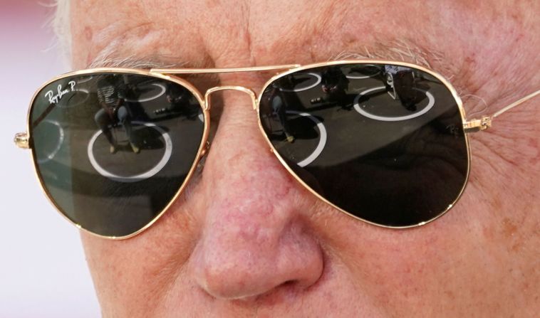 Personas sentadas en círculos de distanciamiento social se reflejan en las gafas de sol de Biden mientras habla en Charlotte, Carolina del Norte.