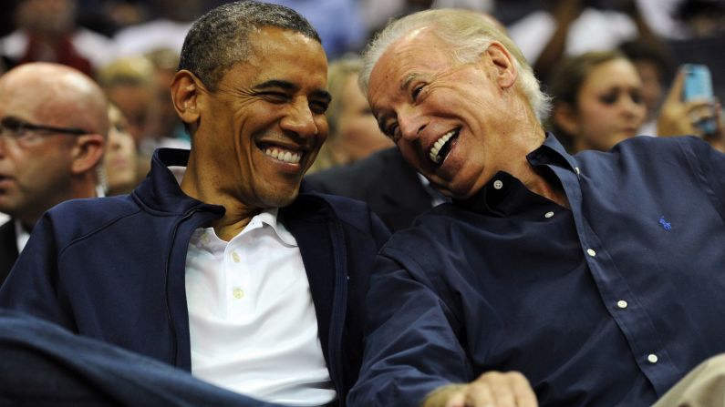 Obama y Biden se ríen juntos mientras asisten a un juego de baloncesto en julio de 2012.