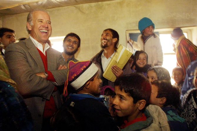 Biden, como presidente de la Comisión de Relaciones Exteriores del Senado, se ríe con los estudiantes mientras visita una escuela secundaria en Kabul, Afganistán, en 2002.
