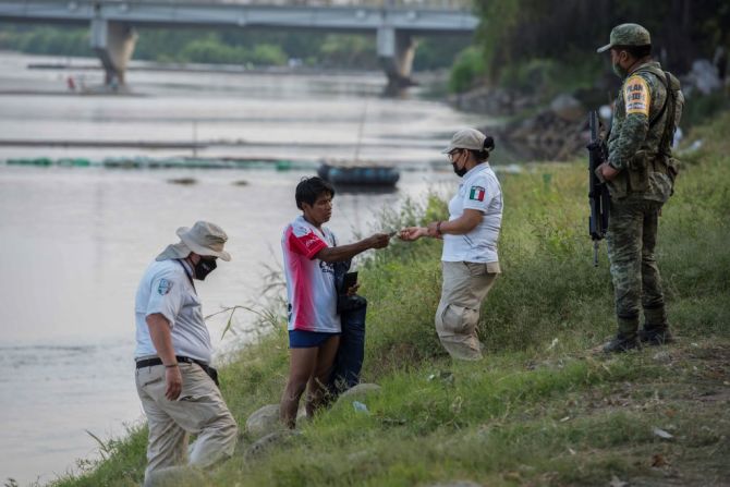 Funcionarios del Instituto Nacional de Migración de México revisan la documentación de personas cruzando el río Suchiate desde Guatemala.