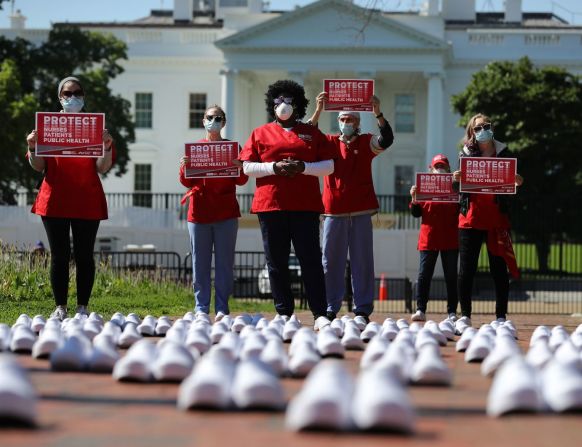 Durante una protesta en Washington, el 7 de mayo de 2020, miembros de National Nurses United se paran entre zapatos vacíos que, según dicen, representan a las enfermeras que murieron a causa del covid-19.