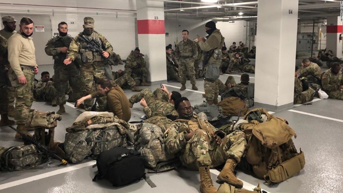 Algunos miembros de la Guardia Nacional se ven descansando en un estacionamiento del Capitolio de EE.UU., luego de días de servicio para asegurar la toma de posesión de Biden.