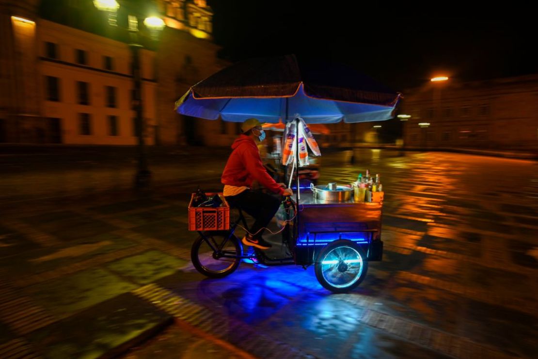 Un vendedor ambulante conduce su carro de comida antes de que comience el toque de queda en Bogotá.