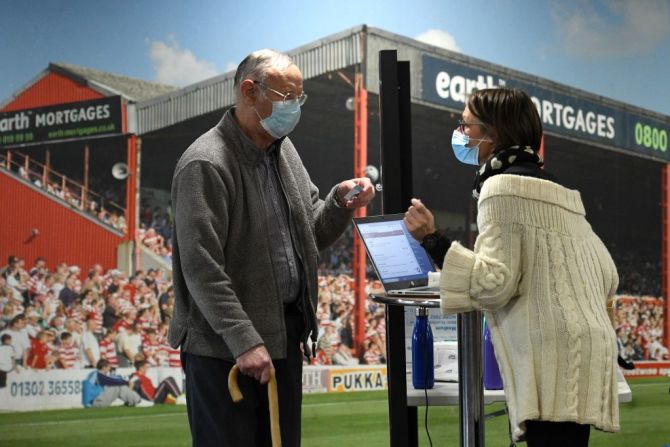 Un hombre se registra para recibir la vacuna Oxford/AstraZeneca en el centro temporal de vacunación en el estadio Keepmoat en Doncaster, Inglaterra.